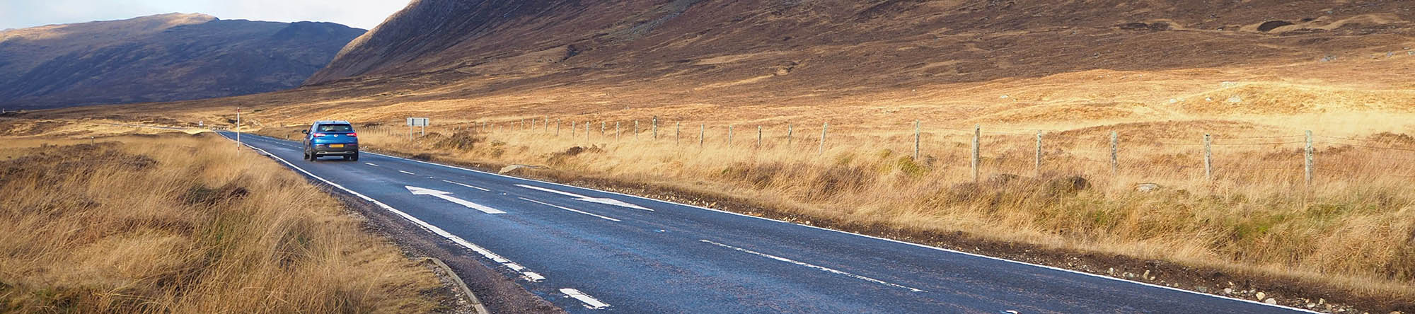 Car driving through the Scottish Highlands